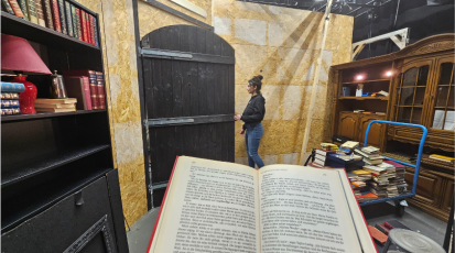 offenes Buch dahinter steht eine Frau in einer Bücherei, die eine Tür öffnet