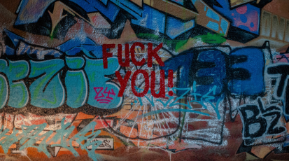 Graffiti-Wand mit rotem "Fuck you"-Schriftzug