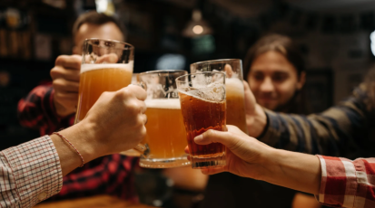 Freunde stoßen mit Bierkrügen an.