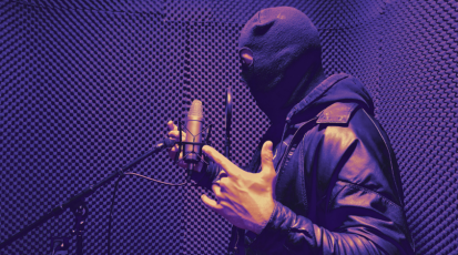 Rapper, der mit Sturmmaske in einem Tonstudio ein Lied aufnimmt.