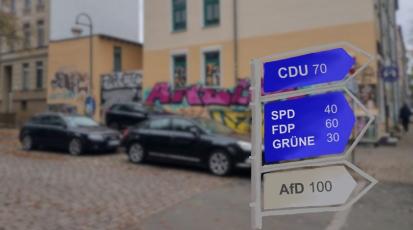 Ein Straßenschild zeigt die Richtung der Parteien an.