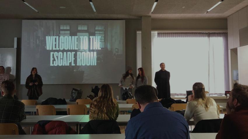 Studierende sitzen in einem Vorlesungssaal und schauen einer Präsentation zu Universitäten der Zukunft zu.