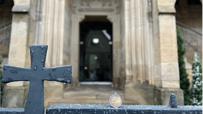 Kirche im Hintergrund. Geld im Fokus.