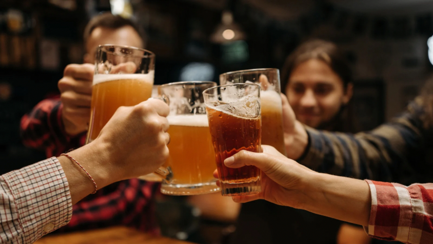 Freunde stoßen mit Bierkrügen an.