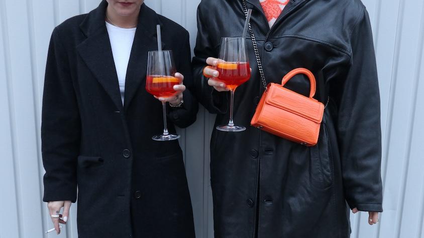 Zwei trendbewusste junge Frauen aus Gen Z mit Aperol Spritz Getränk in der Hand.