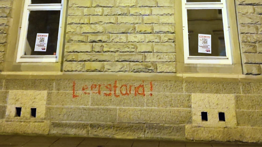 eine Hauswand auf die mit roter Farbe "Leerstand" gesprüht wurde.