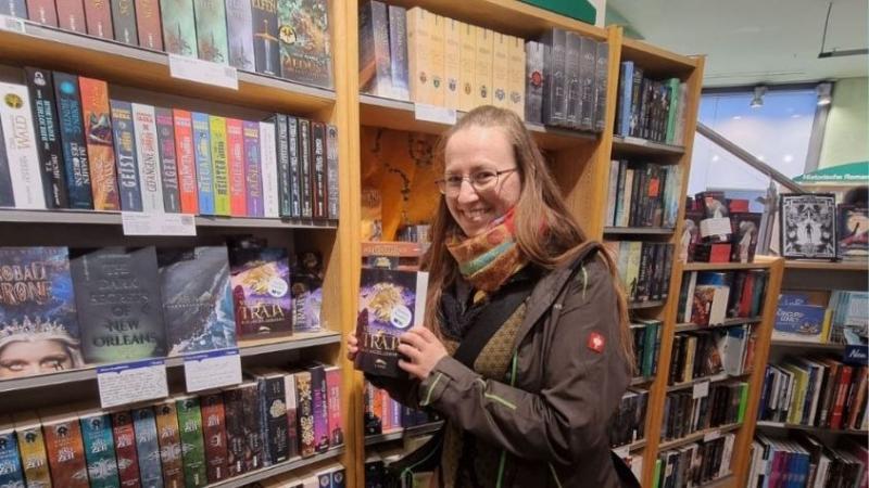 Im Haus des Buches Dresden steht Kathleen Stein vor ihren eigenen Büchern.