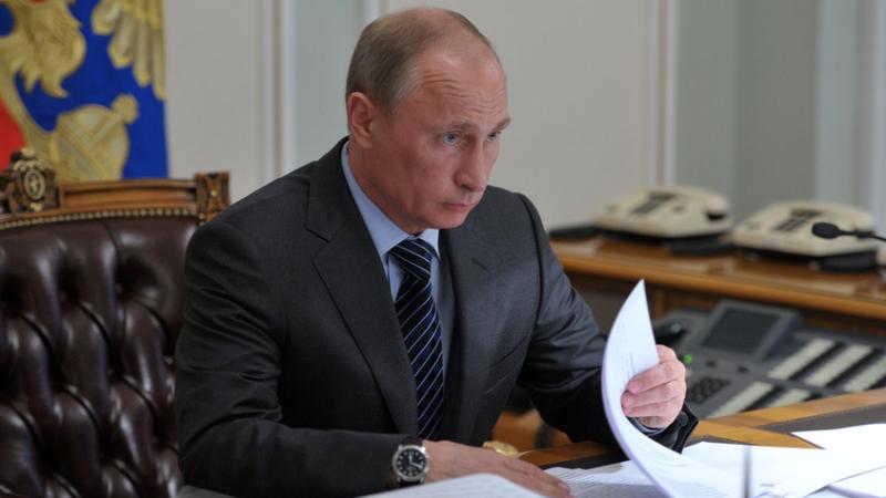 Putin am Durchblättern von Dokumenten