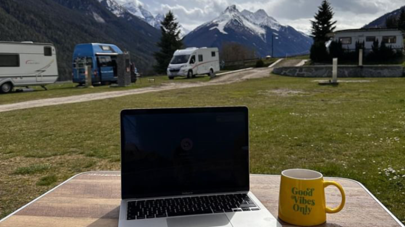 Arbeiten mit Laptop und Kaffeetasse mit Aussicht auf die Berge